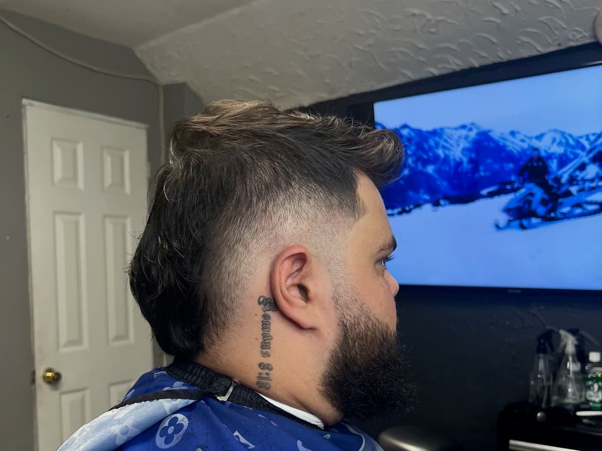 Burst fade with the length left long at the back and a full beard
