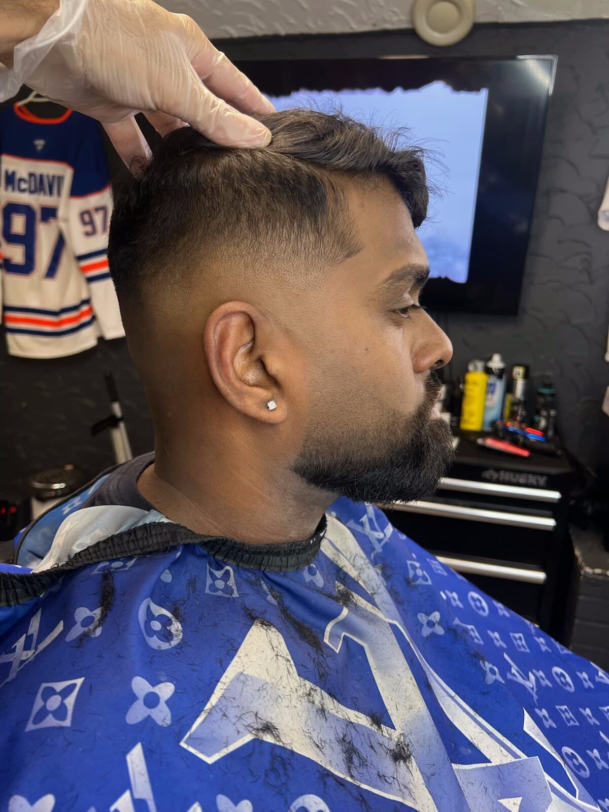 Skin fade in progress, clipper work on the side of the head
