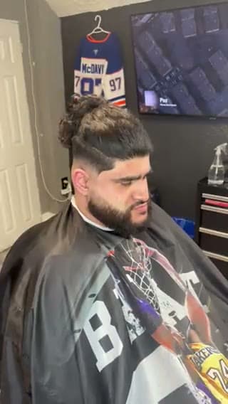 Skin fade with the length tied up and the beard sculpted